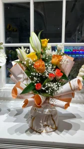 Bouquet of roses for graduated. Orange camelia roses, orange roses with baby's breath, lys, white roses, vegetation. Corean paper for decoration with inscriptions 7rose