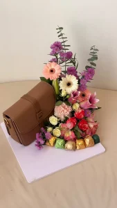 brown women handbag to offer as a gift with chocolates and flowers. copie.webp